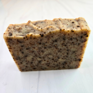 A rectangular bar of handmade soap with a speckled beige and dark brown texture, photographed on a light white background.