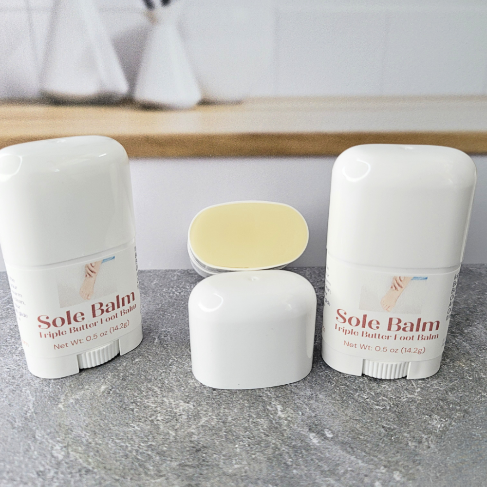 Two tubes of Sole Balm Triple Butter Foot Balm, with another tube open and resting on it's side