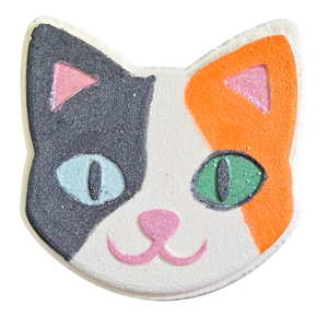 Kitty bath bomb painted with calico kitty colors, black-white-orange, one blue eye and one green eye