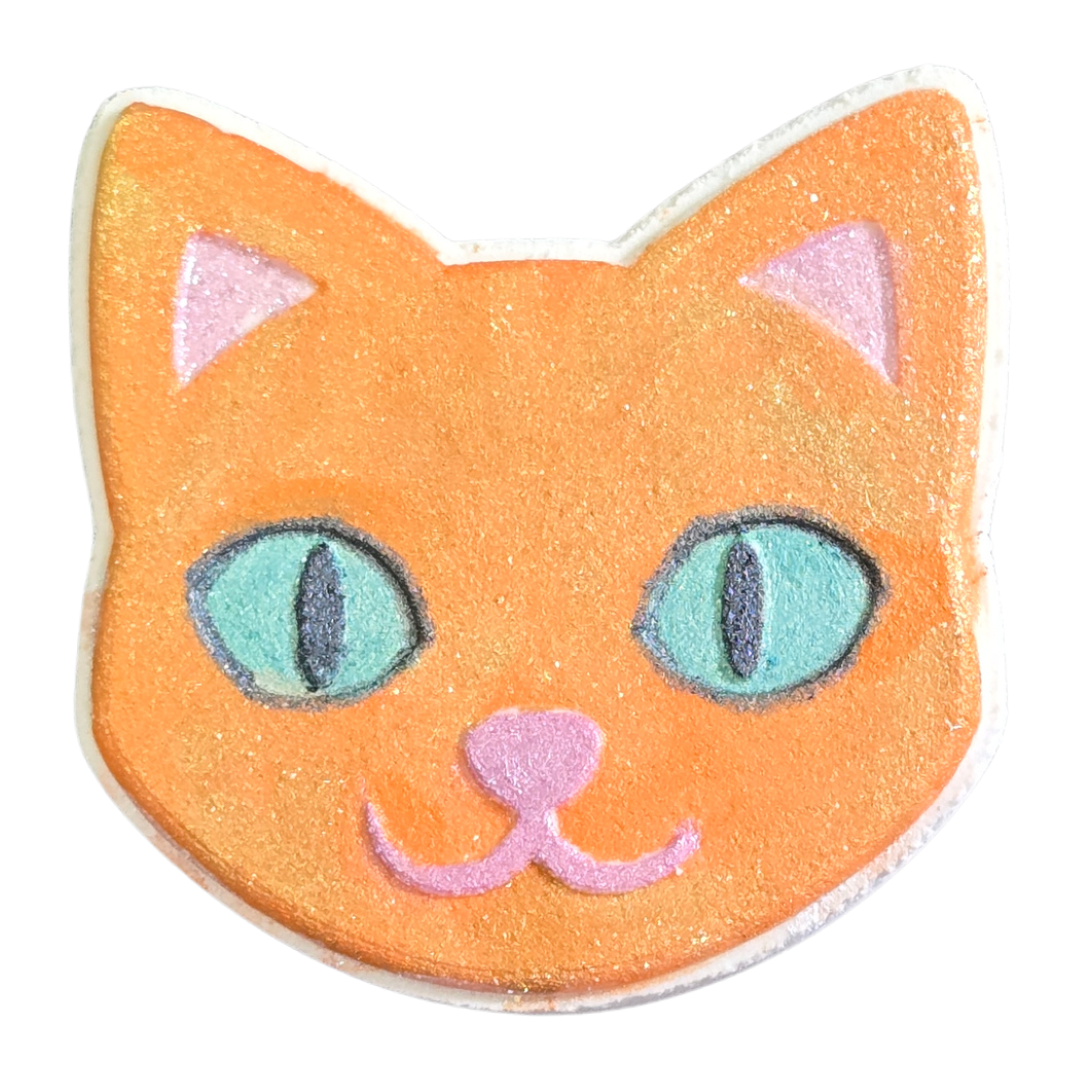 Kitty bath bomb painted with orange tabby kitty colors, orange and gold highlights, with green eyes